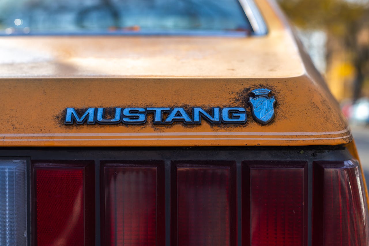 Fotografía detallada en primer plano del emblema amarillo de un Ford Mustang en la ciudad de Nueva York.